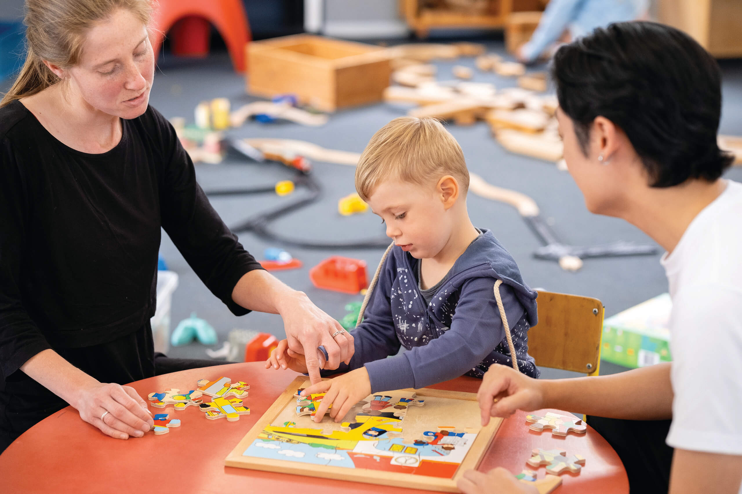 Young boy with two adults puzzle